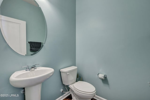 bathroom featuring baseboards, toilet, and wood finished floors