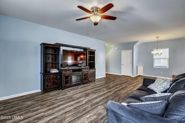 living area with ceiling fan with notable chandelier, wood finished floors, visible vents, and baseboards