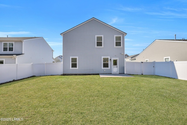 rear view of property featuring a fenced backyard, a lawn, and a patio