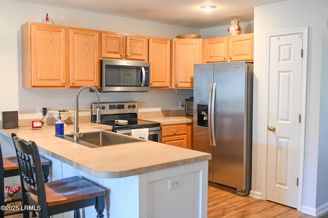 kitchen featuring sink, a breakfast bar area, stainless steel appliances, and kitchen peninsula