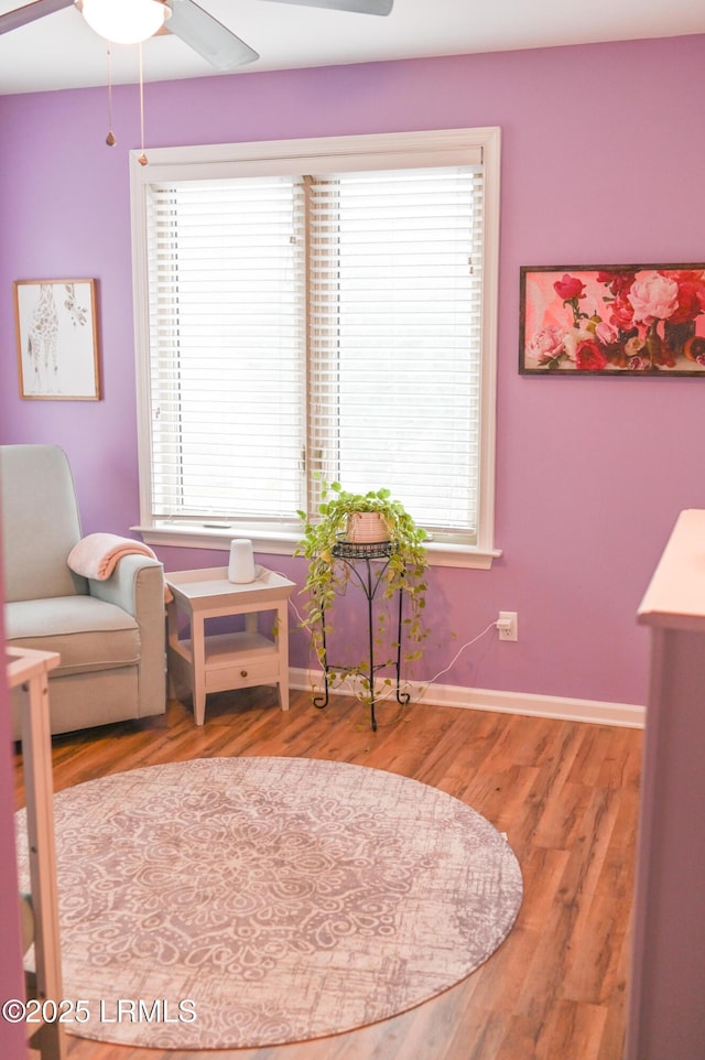 living area featuring hardwood / wood-style flooring and ceiling fan