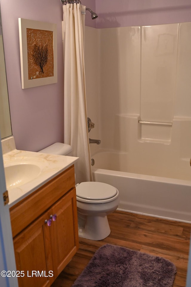 full bathroom featuring shower / bathtub combination with curtain, vanity, hardwood / wood-style flooring, and toilet