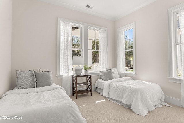 bedroom featuring baseboards, multiple windows, visible vents, and light colored carpet