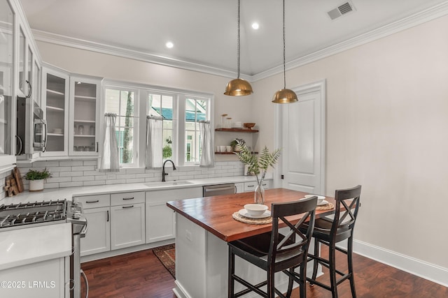 kitchen with open shelves, visible vents, white cabinetry, a kitchen island, and a sink