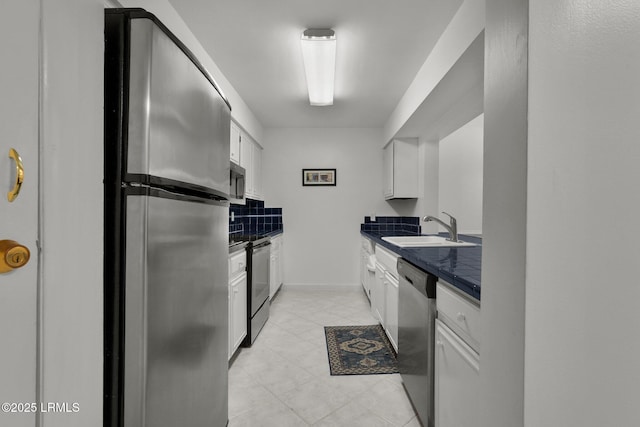 kitchen featuring white cabinetry, sink, decorative backsplash, and stainless steel appliances