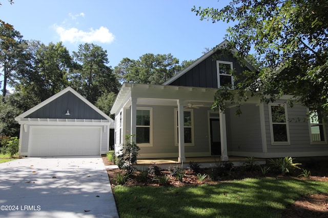 view of front of home with a garage, covered porch, and a front lawn