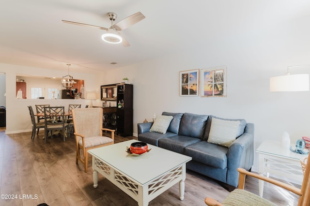 living room featuring hardwood / wood-style flooring and ceiling fan with notable chandelier