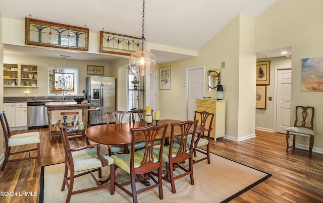 dining room with lofted ceiling, sink, and wood-type flooring