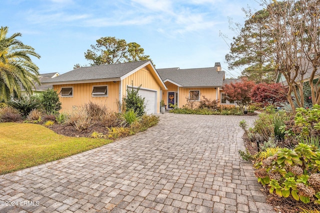 single story home featuring a garage and a front lawn