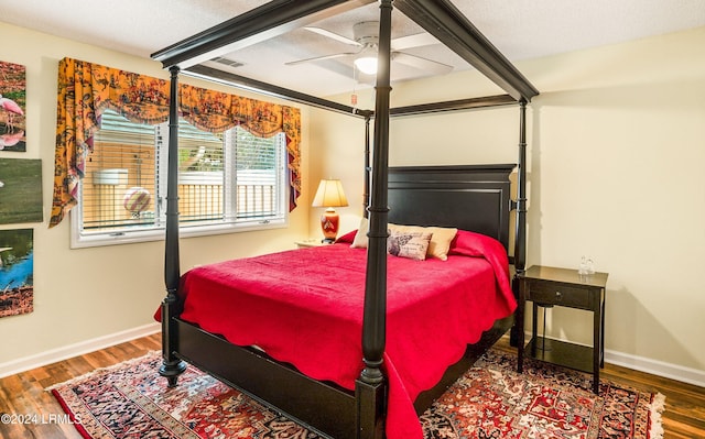 bedroom with hardwood / wood-style flooring, ceiling fan, and a textured ceiling