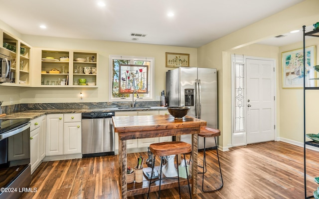 kitchen with white cabinetry, appliances with stainless steel finishes, sink, and dark hardwood / wood-style flooring