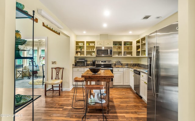 kitchen with white cabinetry, dark hardwood / wood-style floors, and appliances with stainless steel finishes