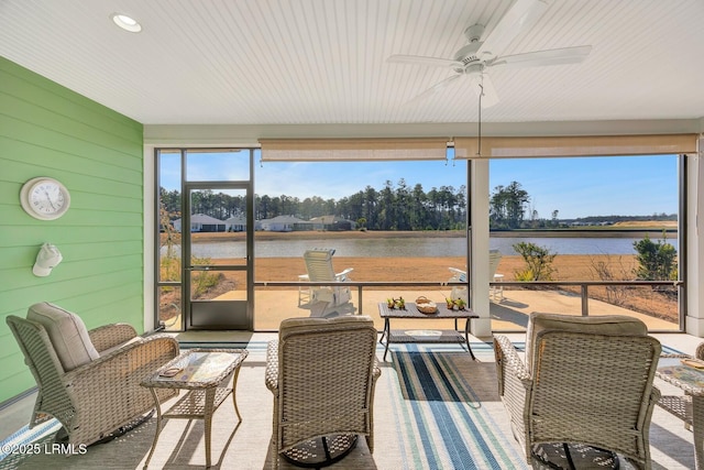 sunroom featuring a water view and ceiling fan