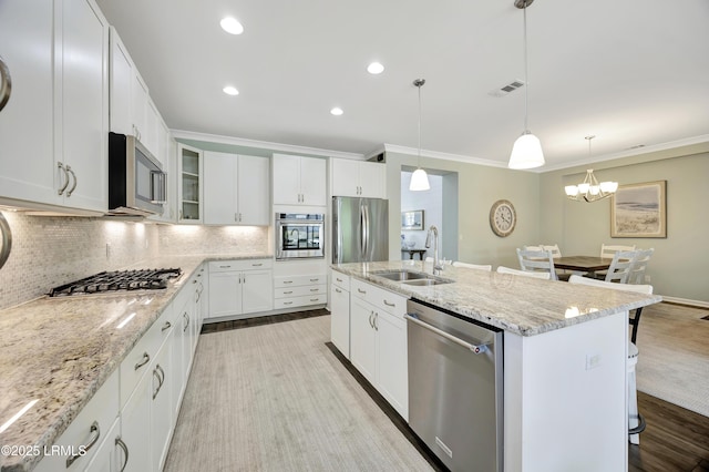 kitchen with an island with sink, white cabinetry, sink, a breakfast bar area, and stainless steel appliances