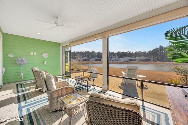 sunroom featuring a water view and ceiling fan