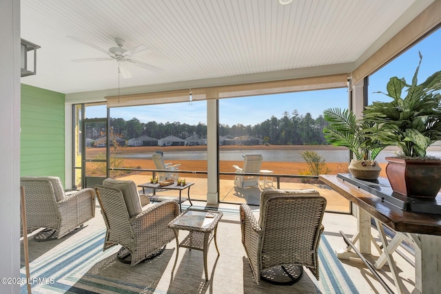 sunroom / solarium featuring a water view and ceiling fan