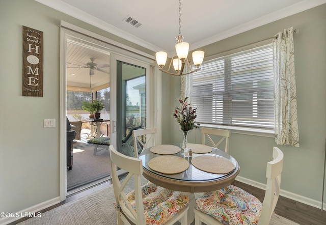 dining area featuring crown molding, a chandelier, and hardwood / wood-style flooring