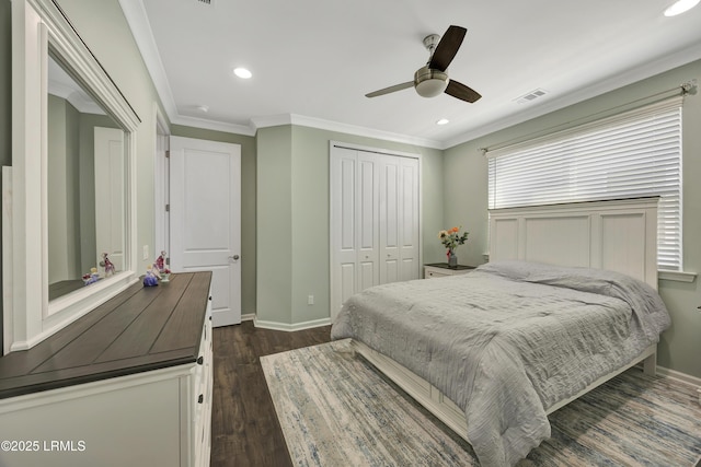 bedroom with ornamental molding, dark wood-type flooring, ceiling fan, and a closet