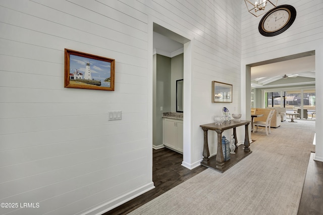 hallway featuring an inviting chandelier and dark hardwood / wood-style flooring