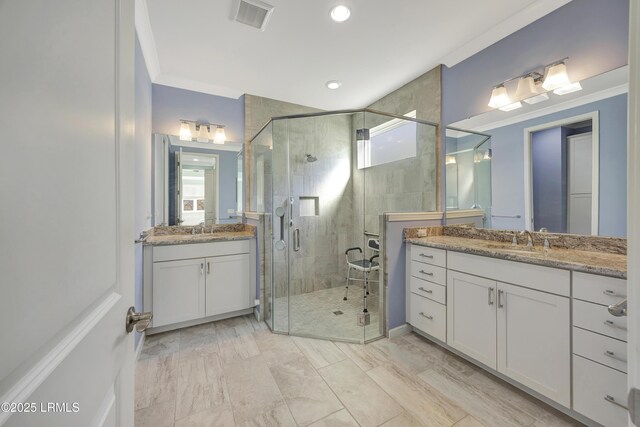 bathroom featuring a shower with door, vanity, and ornamental molding