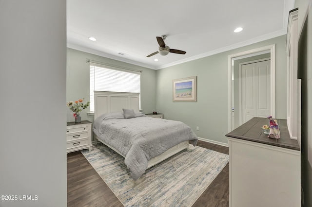 bedroom featuring dark wood-type flooring, ornamental molding, a closet, and ceiling fan