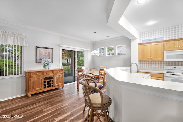 355 Hampton Pl, Bluffton, SC 29909 - kitchen with white appliances, dark wood finished floors, light countertops, a kitchen bar, and decorative backsplash
