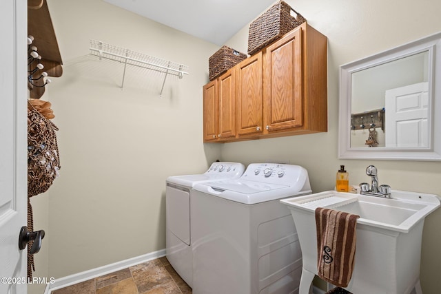 laundry area featuring cabinets, separate washer and dryer, and sink