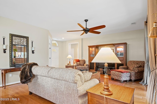 living room with ceiling fan and light wood-type flooring