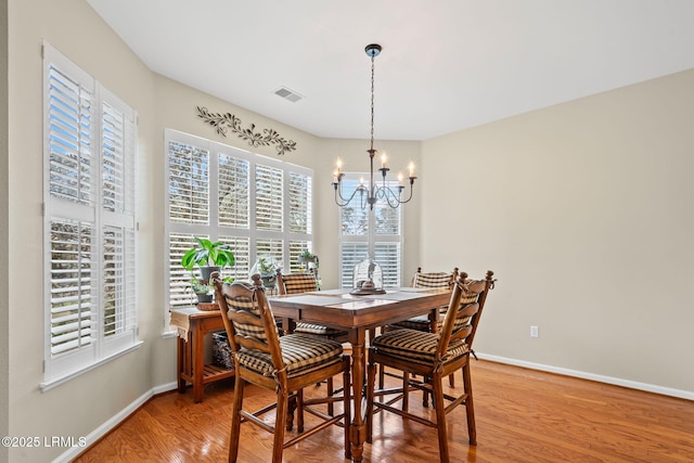 dining area featuring hardwood / wood-style flooring and a notable chandelier