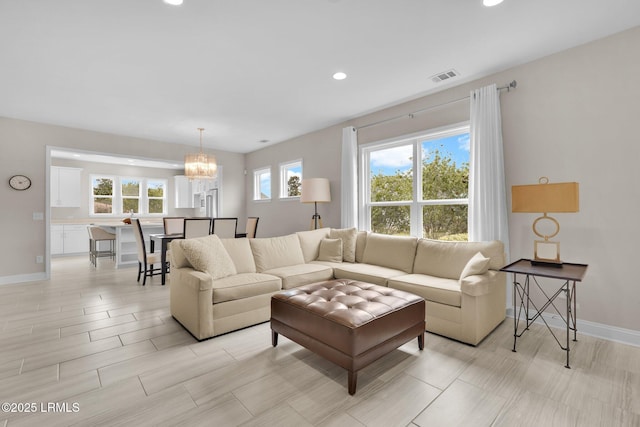 living room featuring baseboards, visible vents, a chandelier, and recessed lighting