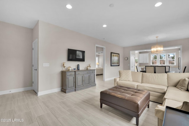 living area with recessed lighting, an inviting chandelier, and baseboards