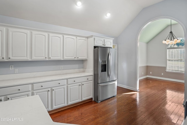 kitchen featuring pendant lighting, lofted ceiling, white cabinetry, dark hardwood / wood-style flooring, and stainless steel fridge with ice dispenser