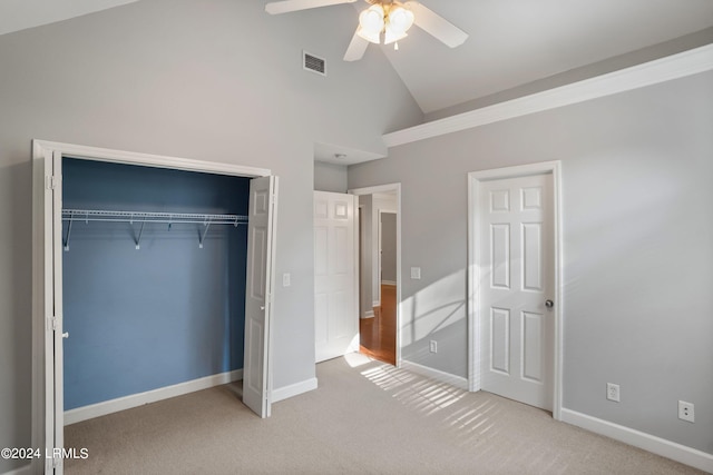 unfurnished bedroom with high vaulted ceiling, carpet flooring, ceiling fan, and a closet