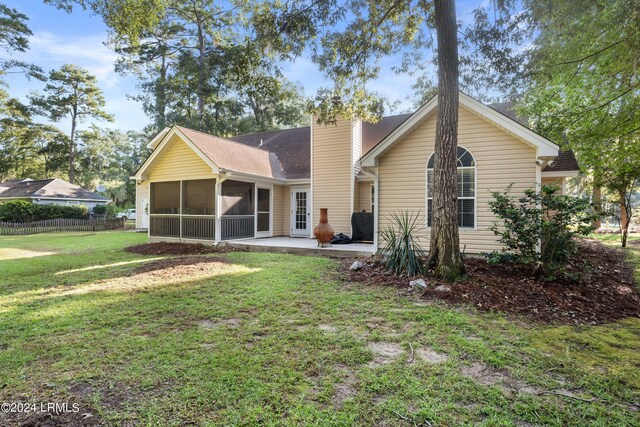 back of property featuring a sunroom, a yard, and a patio area