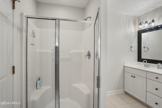 bathroom with tile patterned flooring, vanity, and walk in shower