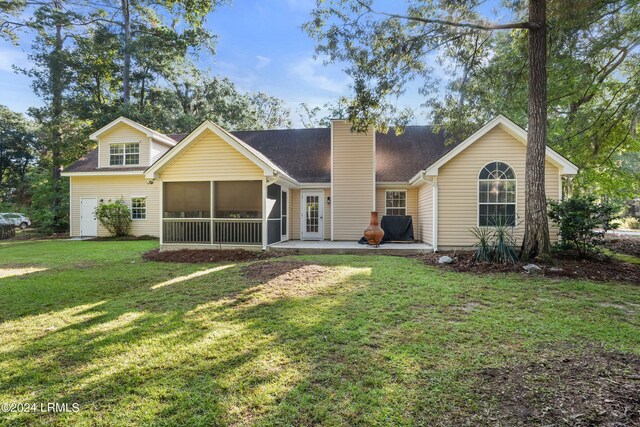 view of front facade featuring a patio, a sunroom, and a front lawn