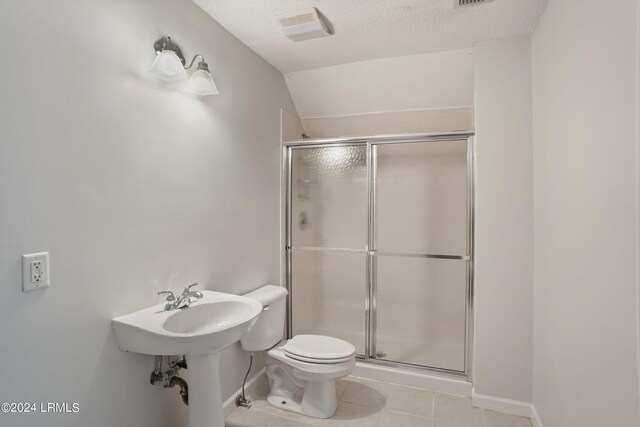 bathroom with tile patterned floors, toilet, an enclosed shower, vaulted ceiling, and a textured ceiling