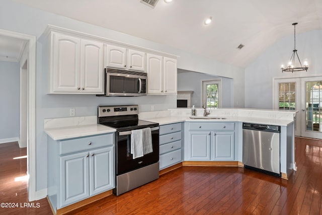 kitchen featuring sink, white cabinetry, hanging light fixtures, appliances with stainless steel finishes, and kitchen peninsula