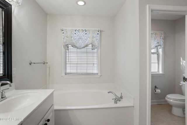 bathroom with vanity, toilet, a bathing tub, and tile patterned flooring