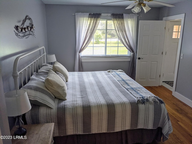 bedroom featuring a ceiling fan, baseboards, and wood finished floors