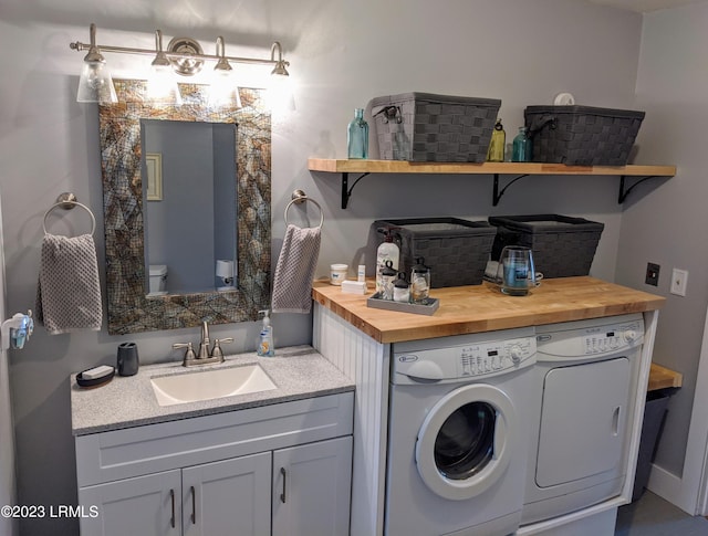 clothes washing area featuring laundry area, independent washer and dryer, and a sink