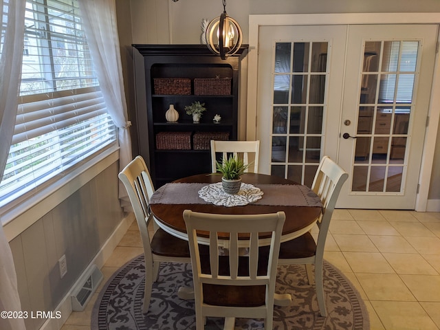 dining space featuring tile patterned floors, visible vents, a notable chandelier, and french doors