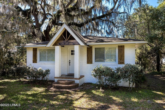 view of front facade with brick siding and a front yard