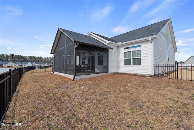 rear view of property featuring a sunroom and a lawn