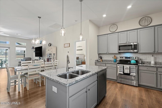 kitchen featuring appliances with stainless steel finishes, decorative light fixtures, sink, and gray cabinetry