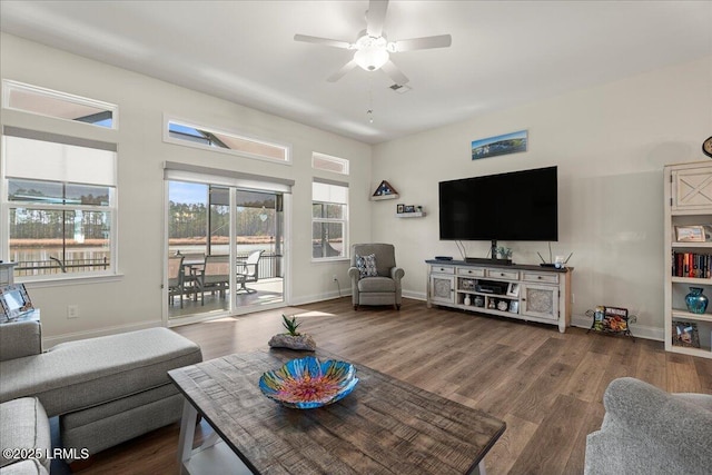 living area featuring dark wood-style flooring, ceiling fan, and baseboards