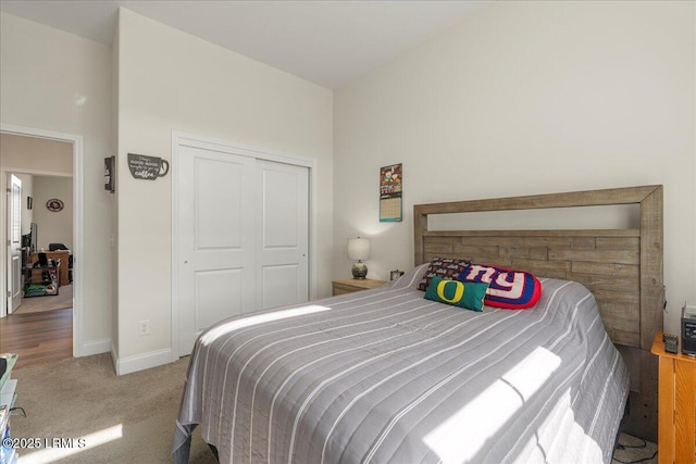 carpeted bedroom featuring a closet and baseboards