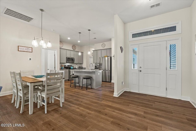 dining room featuring dark wood-style flooring, visible vents, and baseboards