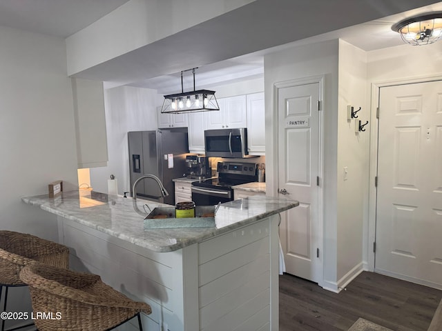 80 Paddle Boat Ln Unit 806, Hilton Head Island, SC 29928 - kitchen with stainless steel appliances, dark wood-style floors, a peninsula, and a breakfast bar area