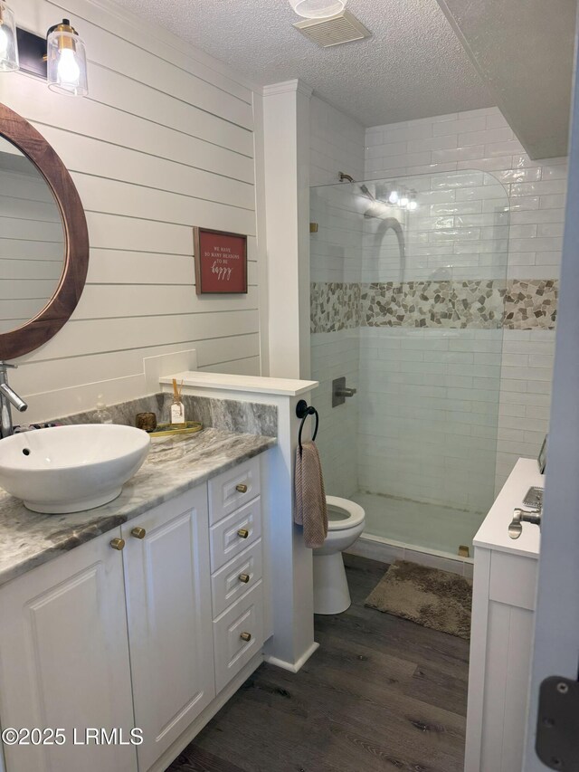 80 Paddle Boat Ln Unit 806, Hilton Head Island, SC 29928 - bathroom featuring vanity, wood finished floors, a tile shower, a textured ceiling, and wooden walls